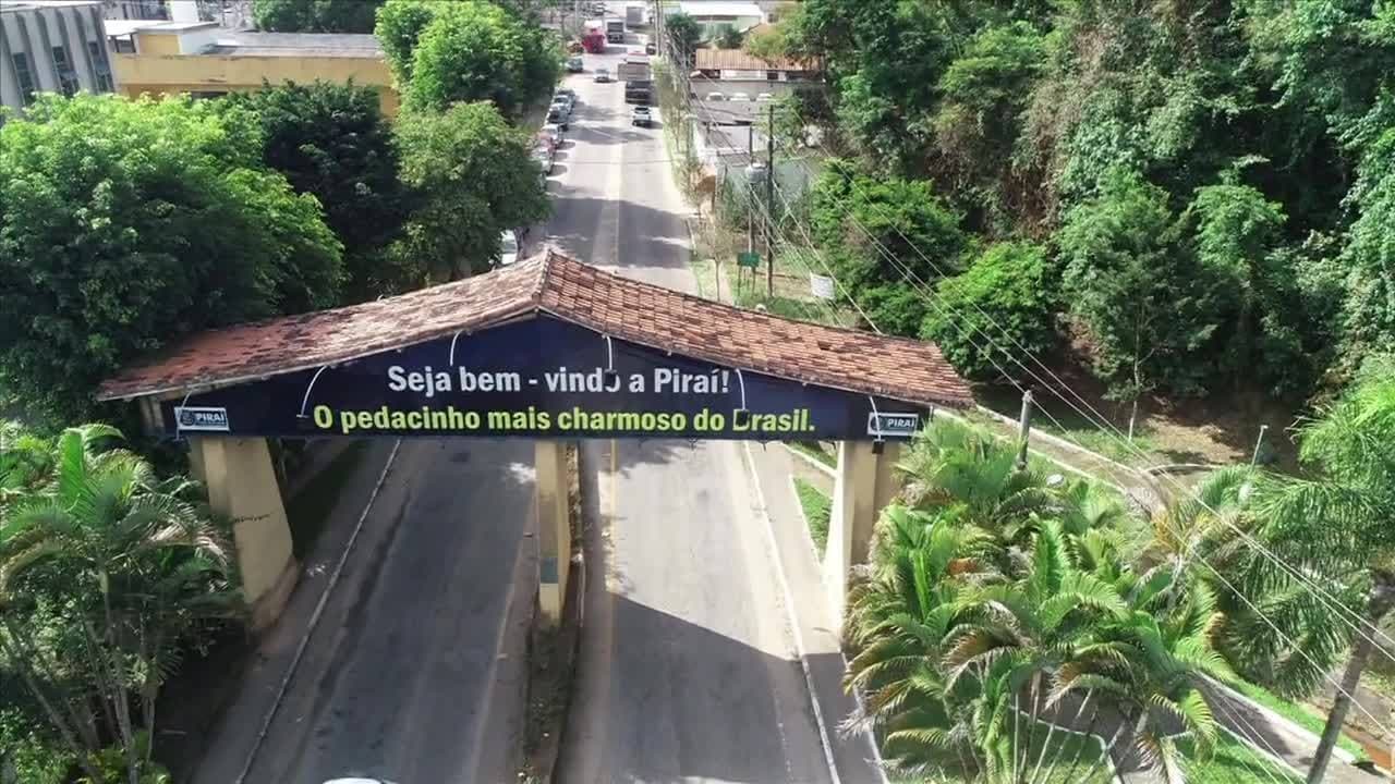 Portal de entrada de Piraí em via cercada por vegetação, no Médio Paraíba